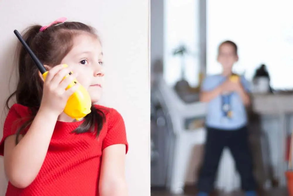 enfant en rouge utilisant un talkie-walkie jaune en intérieur