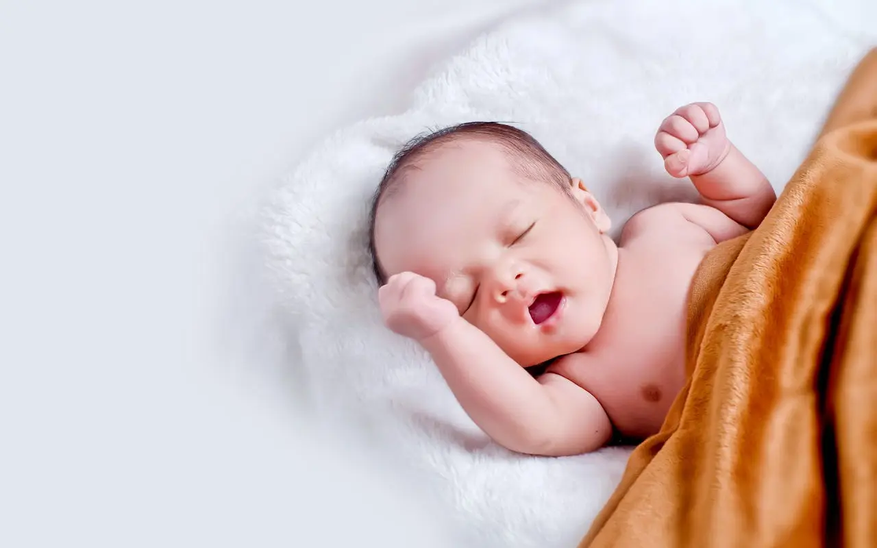 bébé endormi emmailloté dans une couverture blanche naturelle, peau douce visible