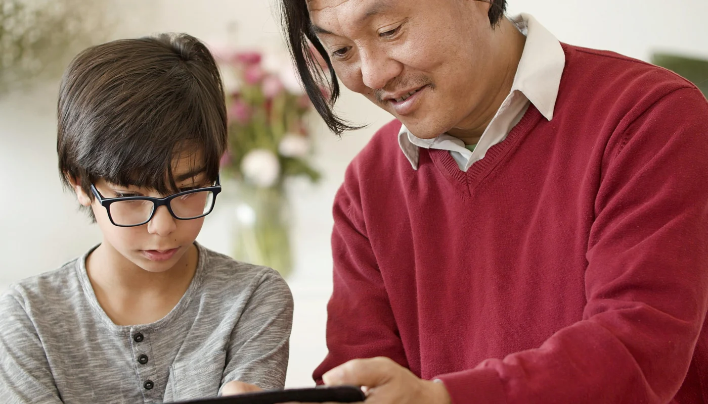 Parent et enfant regardant un programme video ensemble dans le salon