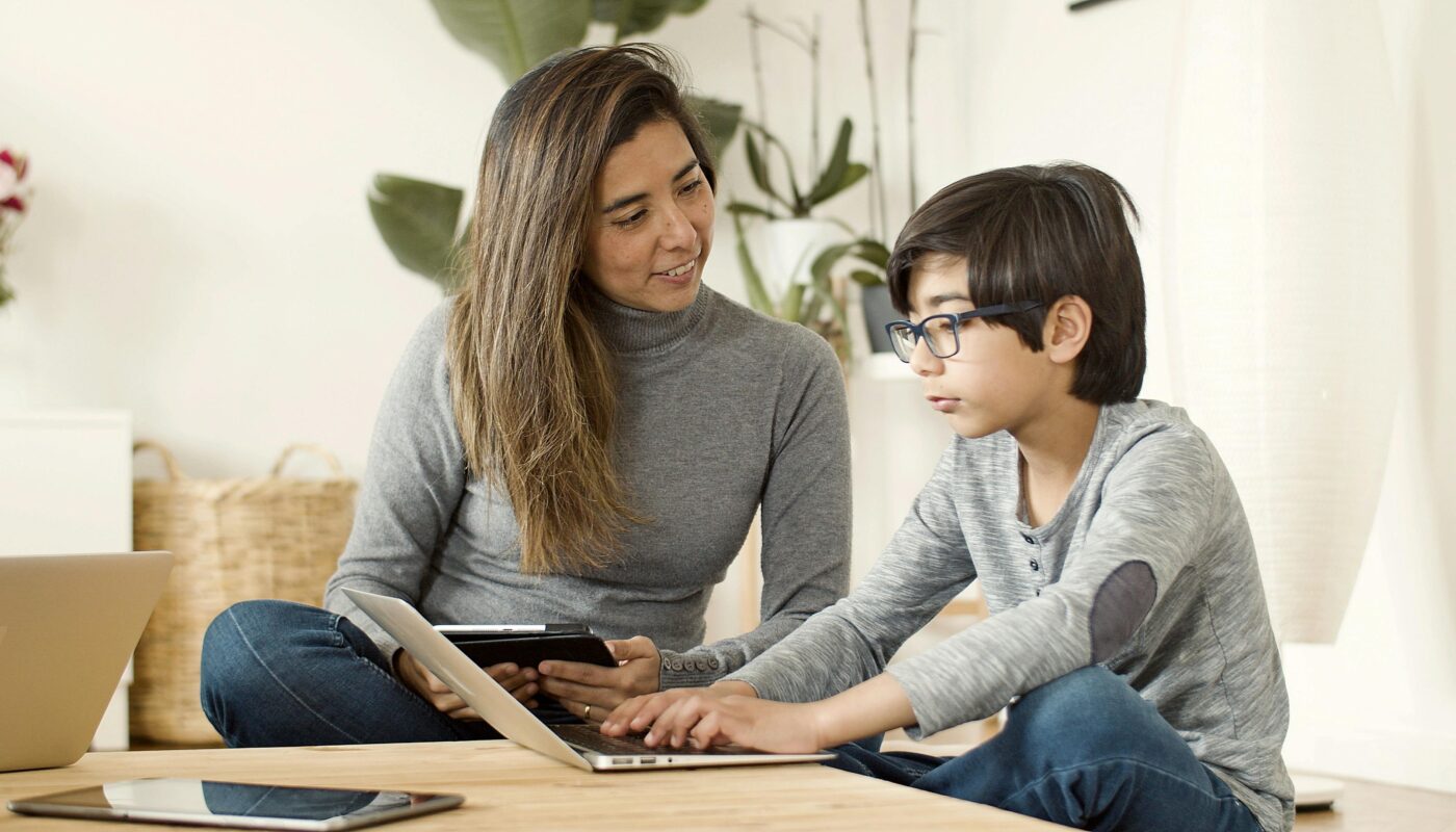 Parent accompagnant un enfant devant une tablette pour regler le controle parental