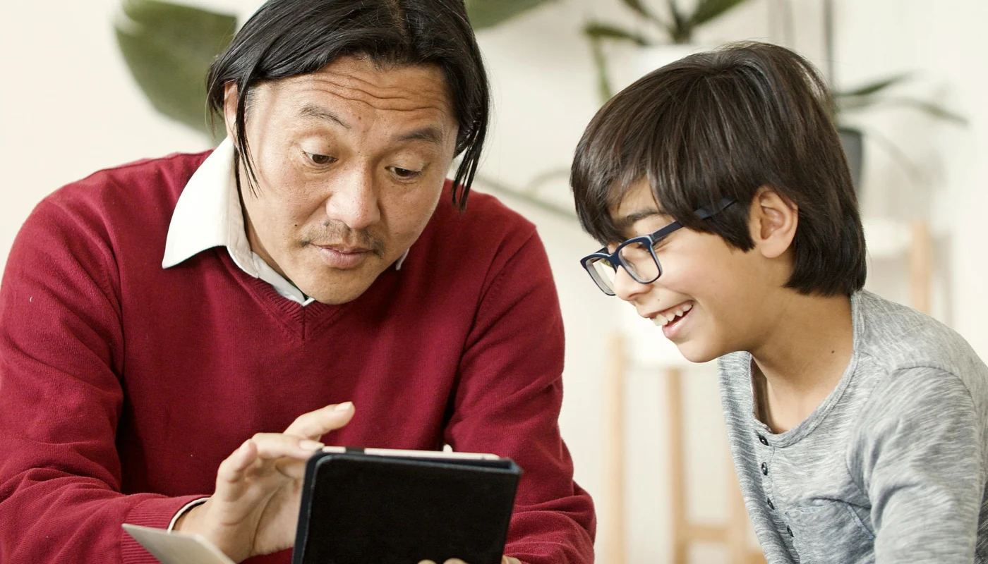 Parent et enfant consultant ensemble une tablette pour regler Family Link