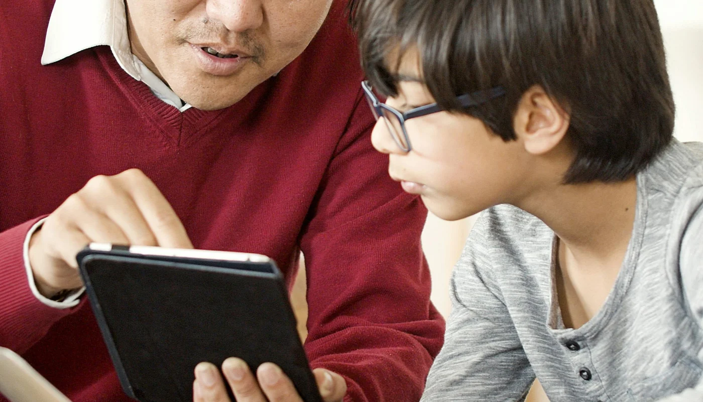 Parent accompagnant un enfant dans les reglages d un premier telephone