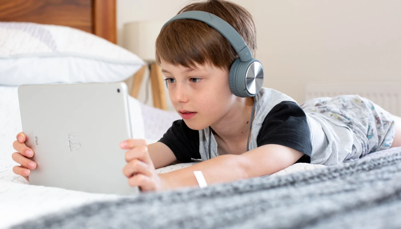 Enfant utilisant une tablette avec un casque pour communiquer en ligne