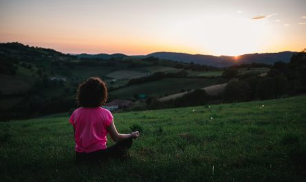 woman sitting on grass field during day